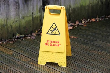 Caution slippery floor surface sign called attention sol glissant in french language