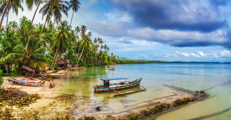 Fototapeta na wymiar Boats on the beach of a secluded tropical island