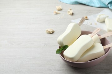 Delicious glazed ice cream bars, chocolate and mint on white wooden table. Space for text
