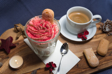 Dessert of whipped cream, savoyardi cookies and raspberry sprinkles with a cup of hot espresso coffee without milk