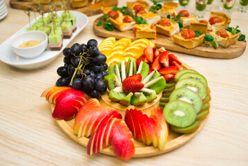 beautifully sliced fruit, a snack of sliced fresh ripe fruit on a wooden round tray