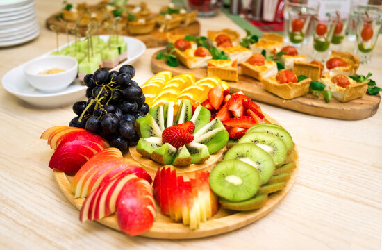 beautifully sliced fruit, a snack of sliced fresh ripe fruit on a wooden round tray