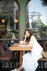 Beautiful smiling asian women sitting in cafe drink coffee shop