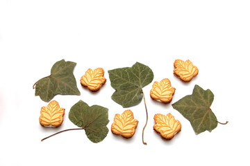 Delicious cookies filled with vanilla cream made with honey or maple syrup from Canadian trees, the traditional sweet of Canada with dry leaves on white background