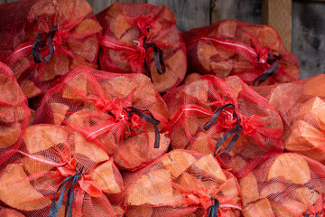 Bundles of firewood in red mesh bags