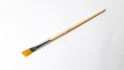 Top view of a variety of artist brushes on a white background with copy space for text. Creative postcard.