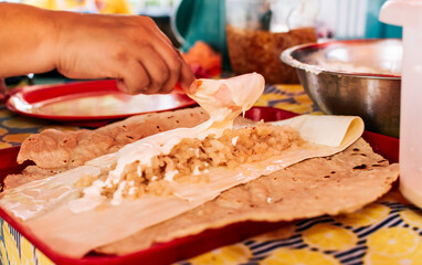 Hands making Nicaraguan Quesillo. Central American food the Quesillo, View of the traditional Quesillo with pickled onion, Preparation of the Traditional Nicaraguan Quesillo