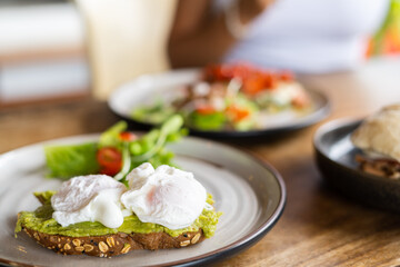 Poached eggs on a table in a summer street cafe, natural light, excellent breakfast