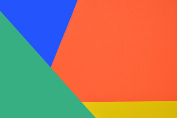 Several sheets of colored paper are stacked on top of each other for the background.