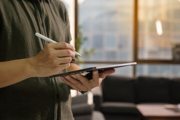 Close-up of a young businessman working on wear suit touch tablet pen.architect design in the office