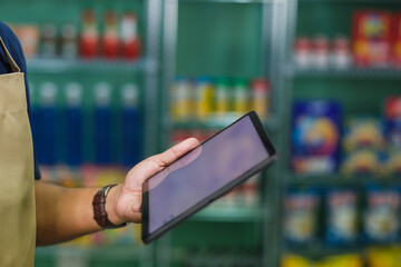 A store clerk checks the products in the store through an app on the tablet warehouse Order online, delivery