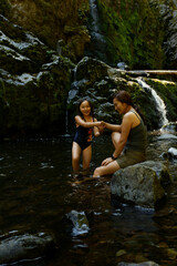 A daughter and mother enjoying a day wading in a pool of Little Mashel River Falls in Eatonville,...