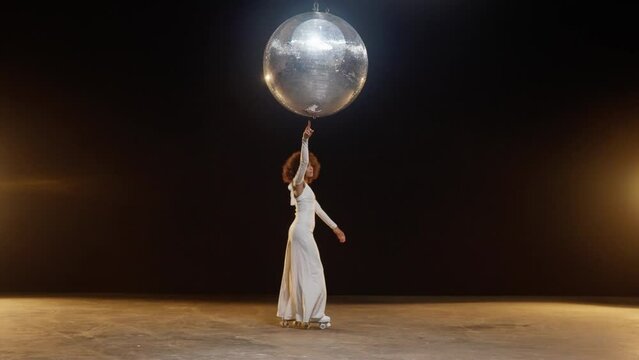 Charming African American Woman in Roller Skates Rides Around Under Disco Ball