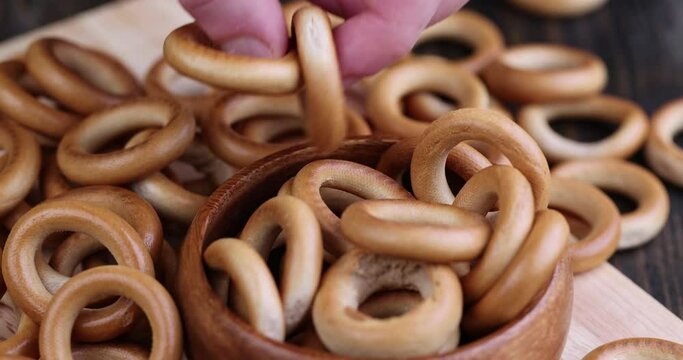 take a hard bagel from the pile of the table with your hand, delicious traditional Russian food round bagels for tea