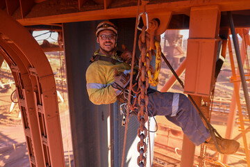 Happy maintenance inspector rope access worker rigger wearing full body industries abseiling safety harness  rising his thumb up after successfully inspecting lifting chain construction site Perth 