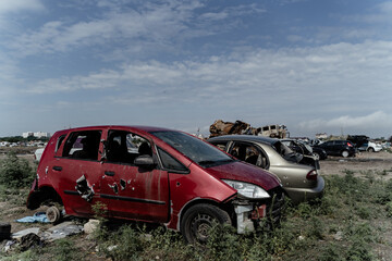 Fototapeta premium The war is between Russia and Ukraine. Red car after being shot with machine guns in Kyiv