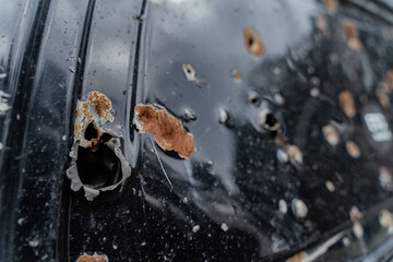 15.07.2022 On broken, burned cars, a close-up shot of areas and holes from shelling and shrapnel...