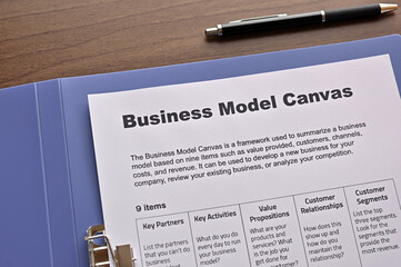 There is dummy documents that created for the photo shoot on the desk about Business Model Canvas.