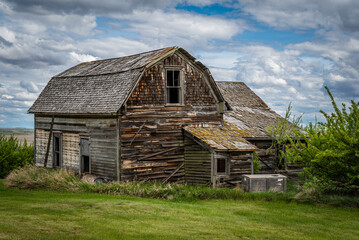 Back view of blue sky over a stately old, abandoned home on the prairies of Saskatchewan 
