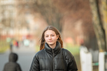 Portrait of a young beautiful fair-haired girl in an autumn jacket close-up. There is artistic noise.