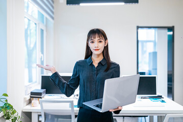 A businesswoman in an office with a black shirt and skirt