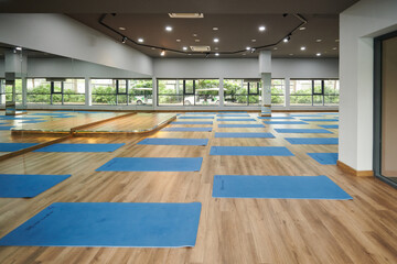 Blue yoga mats rolled out in spacious empty dance studio
