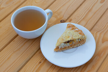 layered sweet cake on the table next to a cup of hot tea. Morning breakfast
