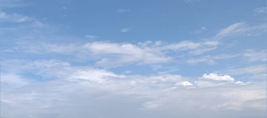 Blue sky and white clouds floated in the sky on a clear day with warm sunshine combined with cool breeze blowing against the body resulting in a miraculous refreshing like paradise.