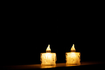 A candle burning in the dark. Light from a candle. Plastic candles.