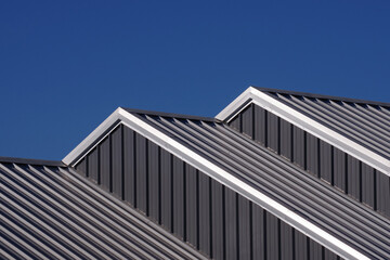 Fototapeta na wymiar Partial view of cascading warehouse rooftops under blue sky
