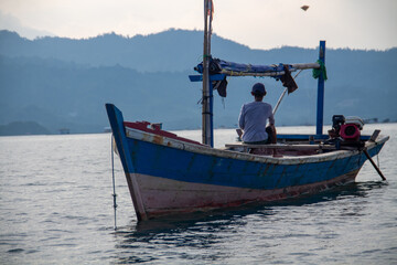 A boat traveling in the middle of the ocean brings people to cross the island
