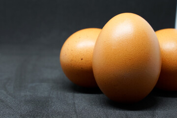 fresh chicken eggs laid out on a black background.