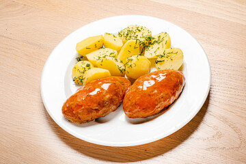 cutlet with baked potato on wooden background