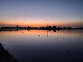 Fototapeta premium sunset and its reflection in water