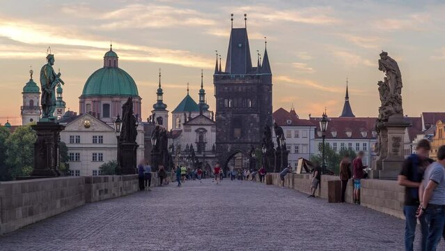 Charles Bridge in Prague with street lights before the sunrise night to day transition timelapse, Bohemia, Czech Republic. Orange sky