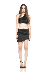 Fototapeta premium Young woman with short, black summer skirt and top, posing in the studio on white