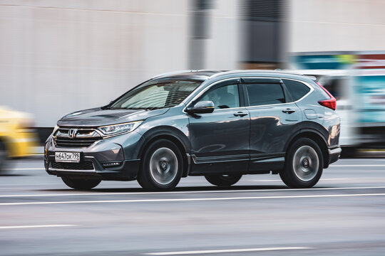 car Honda CR-V driving fast on city street with blurred background.