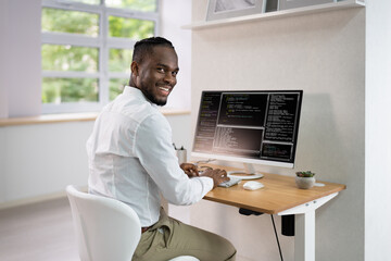 Obraz na płótnie Canvas African American Coder Using Computer At Desk