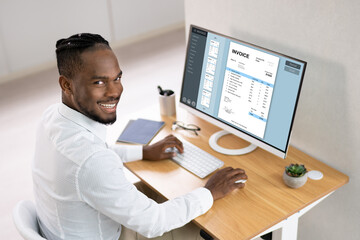 Businessperson Working On Computer With Invoice On Computer