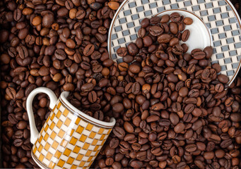 cup and saucer buried in coffee beans, selective focus