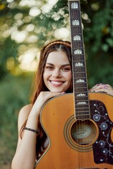 Young hippie woman with eco image smiling and looking into the camera with guitar in hand in nature on a trip 