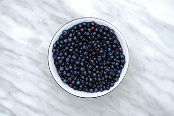blueberries in a white plate on the kitchen table front view close-up