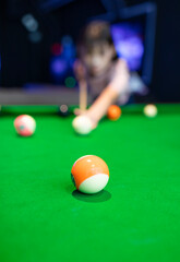 A beautiful woman playing pool in a recreation room