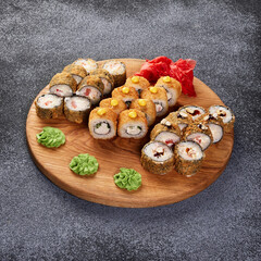 set of hot rolls on a wooden plate on a gray background