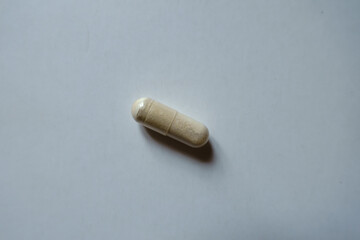 One light beige capsule of Saccharomyces boulardii probiotic from above