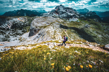 Young woman is hiking on beautiful trail Seekofel to Baires Lake in the Dolomite mountains in the...