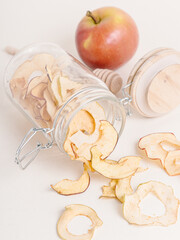 Apple chips in glass jar on white background. Dried apple rings. Healthy sweets