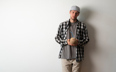 person's hands holding a coconut with straw