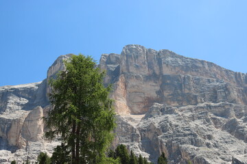 Val Badia, Italy-July 17, 2022: The italian Dolomites behind the small village of Corvara in summer days with beaitiful blue sky in the background. Green nature in the middle of the rocks.