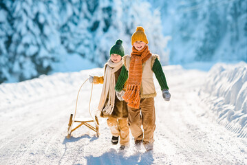 Family kids have fun in the beautiful winter nature with snow-covered trees. Children walk along a...